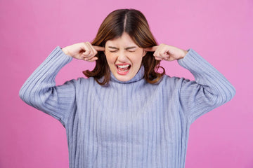 annoyed woman with both her fingers stuck to her ears